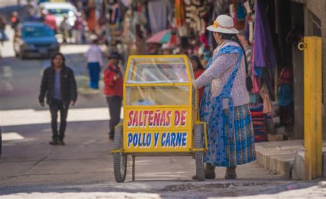 Ilustración de una cholita paceña vendiendo sándwiches en un puesto callejero tradicional