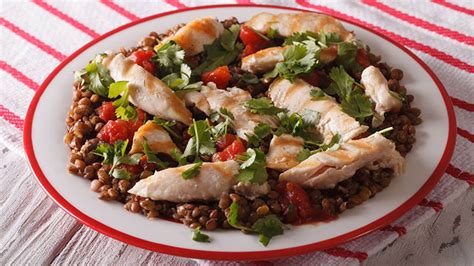 Bol con lentejas cocidas, pollo a la plancha en tiras y vegetales picados (tomate, cebolla, pimiento).