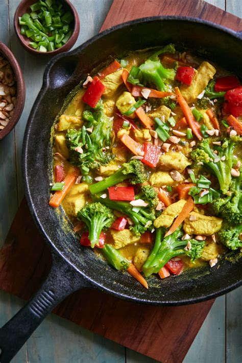 Verduras picadas y pollo salteándose en una sartén grande