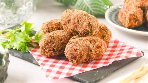 Plato servido con croquetas de atún doradas y una guarnición de arroz blanco y ensalada fresca.