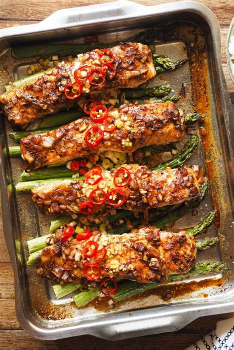 Plato de sushi horneado recién sacado del horno con una capa dorada de salmón y salsas