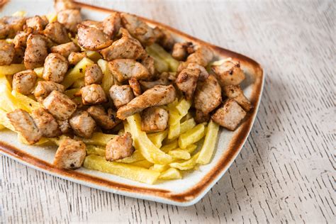 Plato de raxo con patatas, servido en un restaurante.