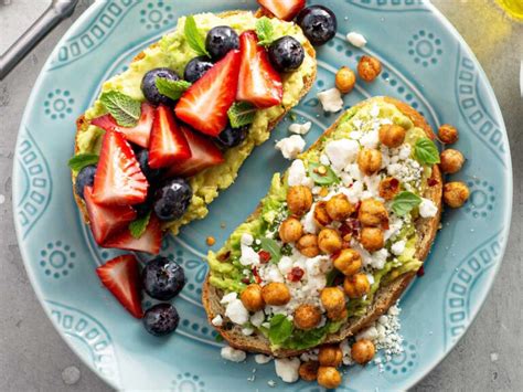 Fotografía de un desayuno colorido con omelette de verduras, tostadas con aguacate y frutos secos, y waffles con frutas.