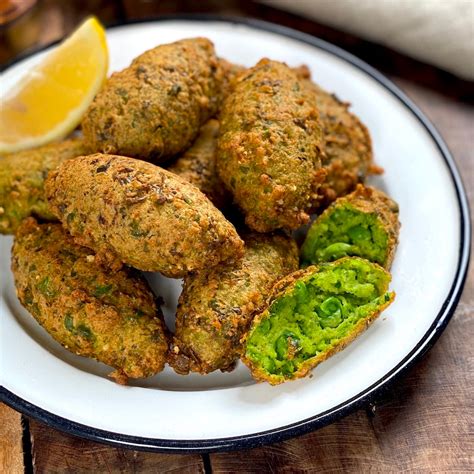 Fotografía de croquetas de arvejas y maíz doradas, presentadas en una bandeja de horno.