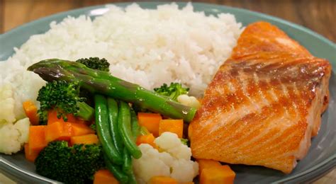 Plato de salmón con salsa de coco y guarnición de arroz