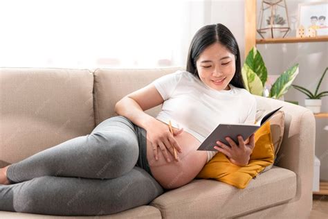 Madre embarazada acariciando su vientre mientras lee un libro