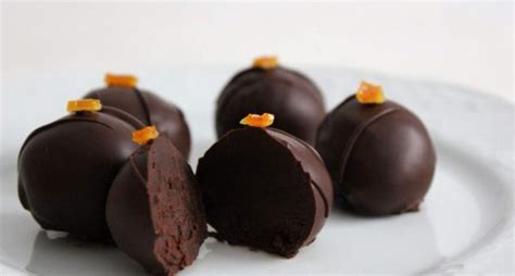 Imagen de varios bombones caseros de chocolate y naranja dispuestos elegantemente.
