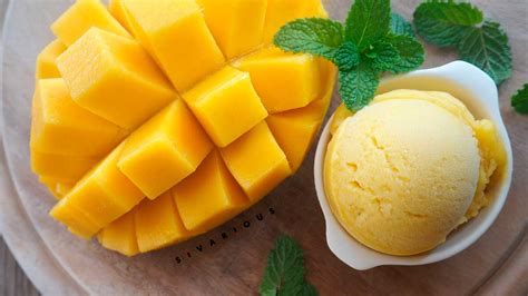 Foto de un bol de helado de mango casero decorado con coco rallado, nueces y una pizca de chile en polvo