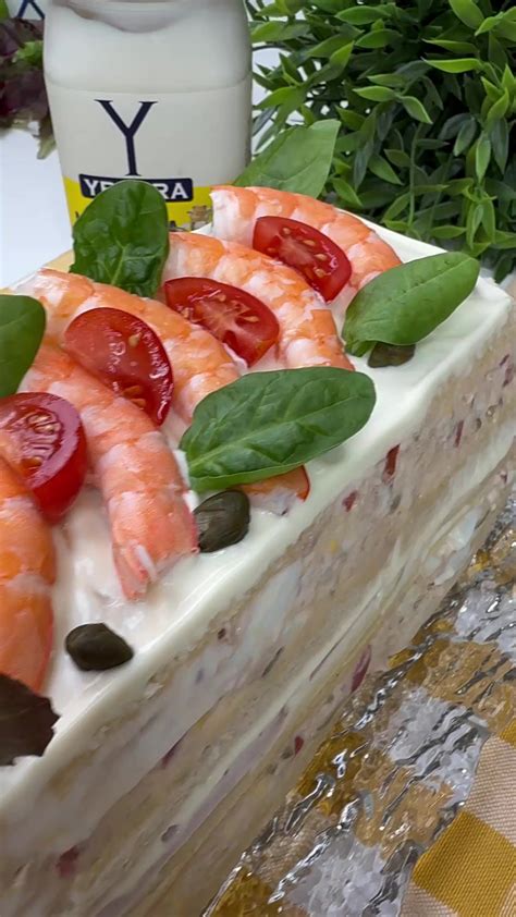 Pastel de atún cremoso desmoldado, decorado con langostinos, aguacate y tomate cherry.