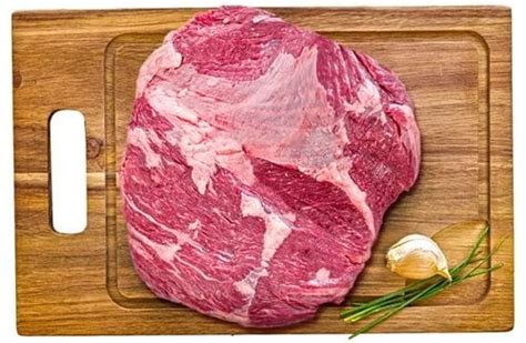 Fotografía de un corte de plateada de vacuno crudo sobre una tabla de madera