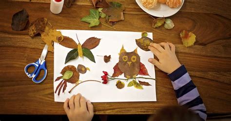 Niños creando arte con elementos naturales como hojas y ramas.