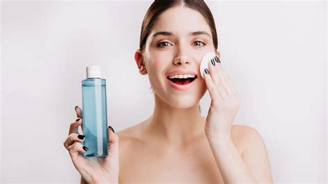 Imagen de una persona aplicando agua micelar en su rostro como paso inicial de preparación de la piel.
