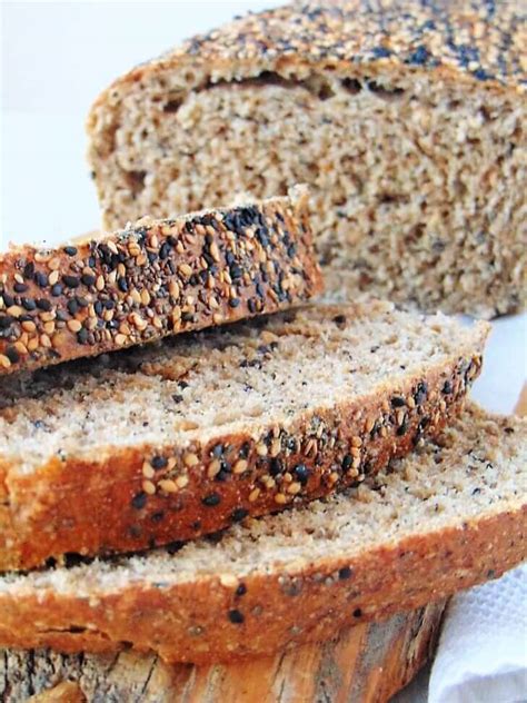 Foto de pan de molde con semillas recién horneado en una tabla de madera