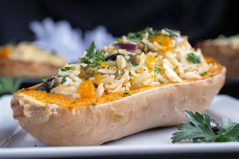 Fotografía de calabazas rellenas de arroz recién horneadas con queso fundido y hierbas aromáticas