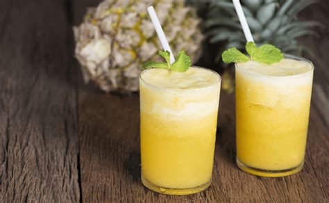 Frutas tropicales y vaso de agua de piña colada con crema