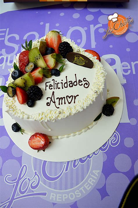 Pastel de cumpleaños decorado con rosetones de crema y frutas frescas