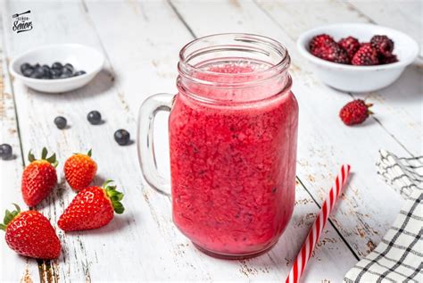 Foto: Presentación de un batido de frutos rojos en vaso de cristal decorado con arándanos frescos