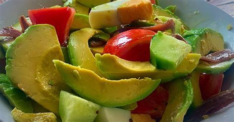 Foto de alta calidad de una ensalada gourmet que combina colores vibrantes de aguacate y tomate de árbol.