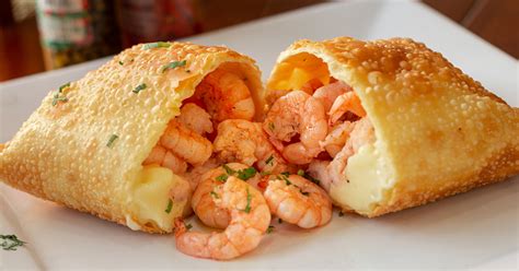 Foto de empanadas de camarón y queso doradas y crujientes recién salidas del horno o fritura.