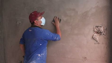 Imagen de una persona lijando una pared con pasta muro