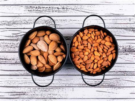 Comparativa visual entre almendras crudas (claras) y tostadas (doradas) antes de su procesado.