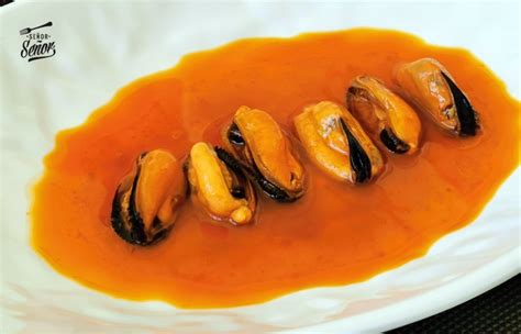 Recipiente con mejillones en escabeche caseros listos