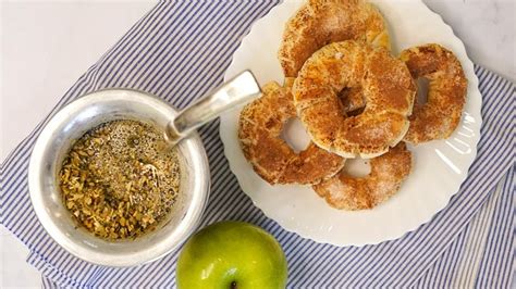 Imagen de donas de manzana recién horneadas con un glaseado de canela y trozos de fruta decorativas