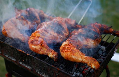 Foto de diferentes cortes de pollo asados en una parrilla de carbón
