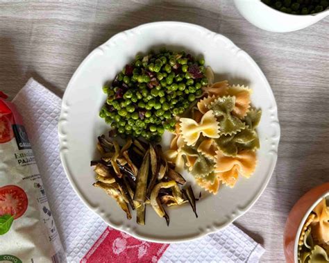 foto temática de un plato de pasta con pajaritas, palmitos y aguacate decorado con formas divertidas para niños