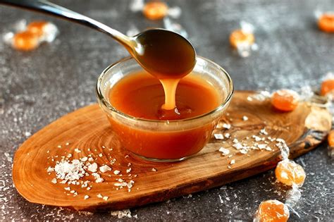 Un frasco de salsa de caramelo Alvi vertiéndose sobre un postre