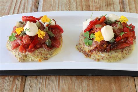 Plato de Crudo Valdiviano presentado sobre pan tostado con salsa y guarniciones
