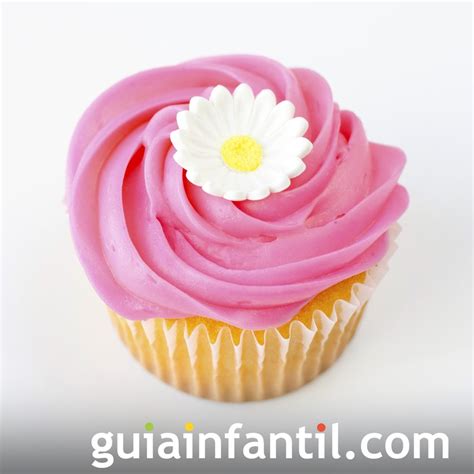 Primer plano de un cupcake decorado con una flor hecha con boquilla rusa y hojas verdes.