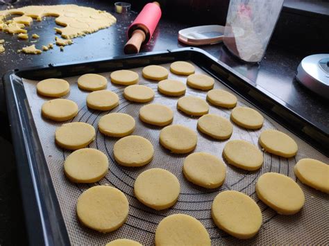 Fotografía de las tapas de alfajor recién salidas del horno sobre una bandeja.
