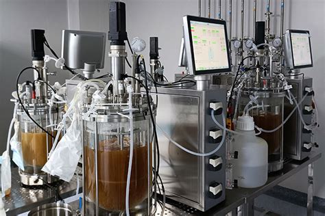 Ilustración de un biorreactor industrial en funcionamiento, mostrando el entorno controlado para el cultivo celular.