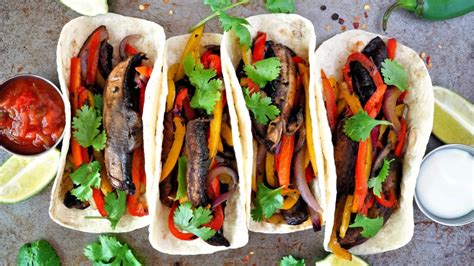 Plato de fajitas veganas con vegetales coloridos, frijoles negros y tortillas