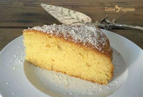 Bizcocho de leche de coco terminado, cortado en porciones, espolvoreado con coco rallado y azúcar glas.
