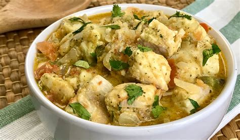 Composición de ingredientes frescos para moqueca: pescado, leche de coco, pimientos, tomates, cebolla y cilantro