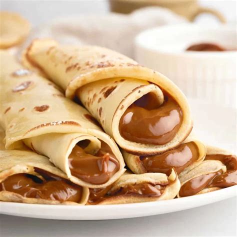 Proceso de capas de panqueque con relleno de dulce de leche en un molde