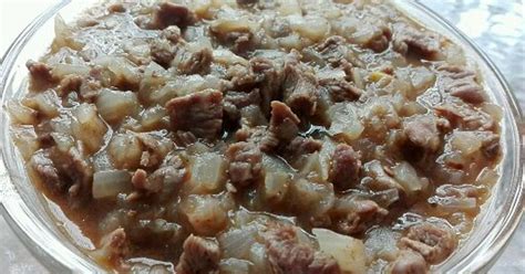 Primer plano de los ingredientes del pino: carne picada, cebolla sofrita, huevo duro, aceitunas y pasas.