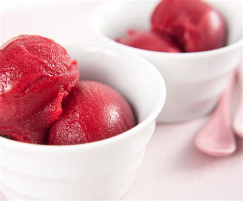 Sorbete de frambuesa de color intenso en un vaso de postre, mostrando su textura suave.