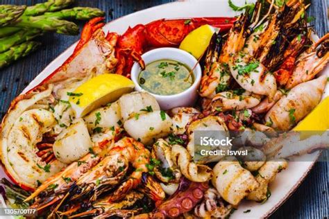 Wok con mariscos salteándose: camarones, mejillones, calamar y langostinos con cebolla cambray y ajo, el camarón empieza a cambiar de color.