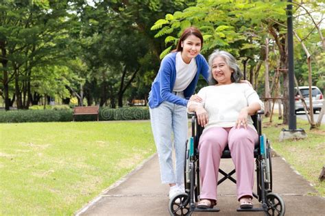 Persona mayor en silla de ruedas con un cuidador