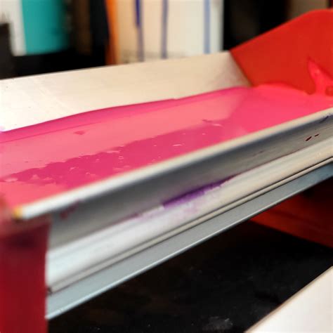 Fotografía técnica de una raedera (emulsionador) de aluminio junto a una pantalla