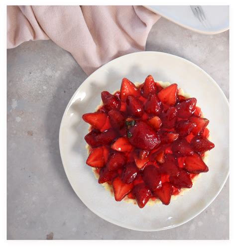 Fotografía de frutillas cubiertas con una sustancia desconocida y una persona realizando una prueba con fuego