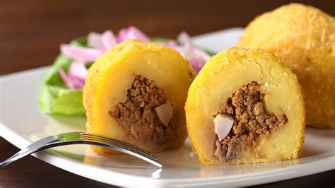 Infografía con los pasos para preparar papa rellena, mostrando la masa, el relleno y el proceso de apanado y fritura.