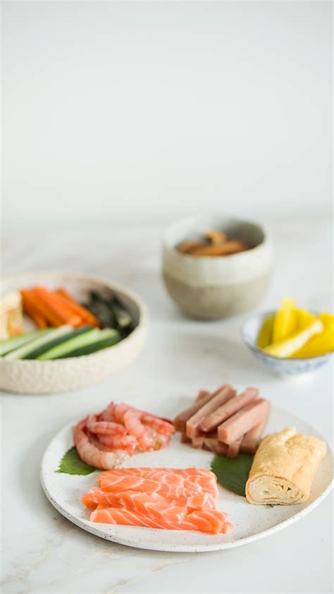 Ingredientes frescos: salmón, atún, gambas y tamagoyaki sobre hoja de shiso