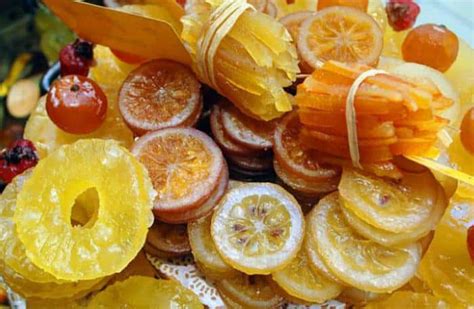 Infografía detallando los pasos para confitar frutas, desde la selección hasta el secado final.