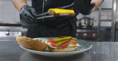 Un chef preparando una hamburguesa vegetal en una cocina moderna.