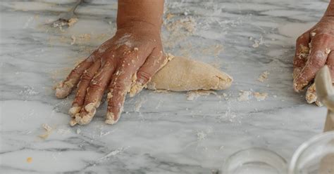 Fotografía de Rosalía Vega amasando la masa de empanada con manos expertas.