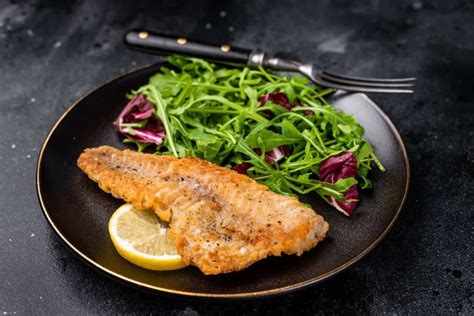 Fotografía de un filete de reineta crujiente recién preparado con guarniciones frescas